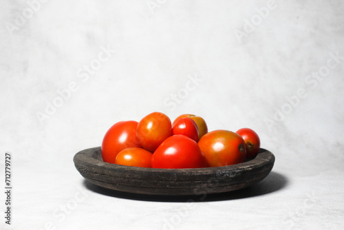 Red tomatoes on wooden plate