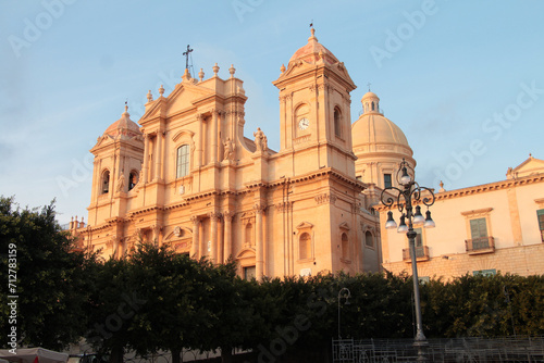 noto sicily italy cathedral wide shot with bushes trees and light post in front