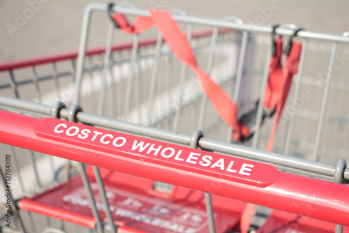 costco wholesale red silver shopping cart close up on costco wholesale writing caption text on handle close up in summer shot on angle