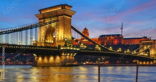 Budapest, Hungary - December 29, 2023: Beautiful sunset. Flooded Danube on the foreground. Chain bridge on the middle ground. Buda castle on the background. Time-lapse, zoom-in animation.