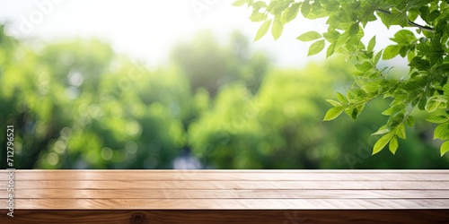 Wooden table on counter with white background  shelf and blurred green tree for food picnic and product display backdrop. Table top surface and blurred garden park in spring and summer outdoor setting
