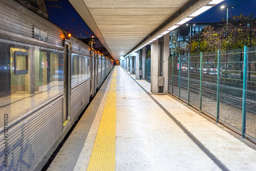 railway station with train carriages on the left and a deep corridor on the right.