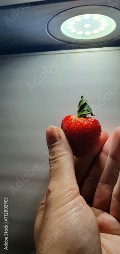 hand holding strawberry