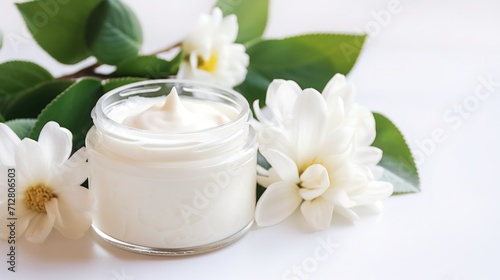 whitening and moisturizing Face cream in an open glass jar and flowers on white background. Set for spa  skin care and body products and solutions for skin problems such as scars  acne  wrinkles.