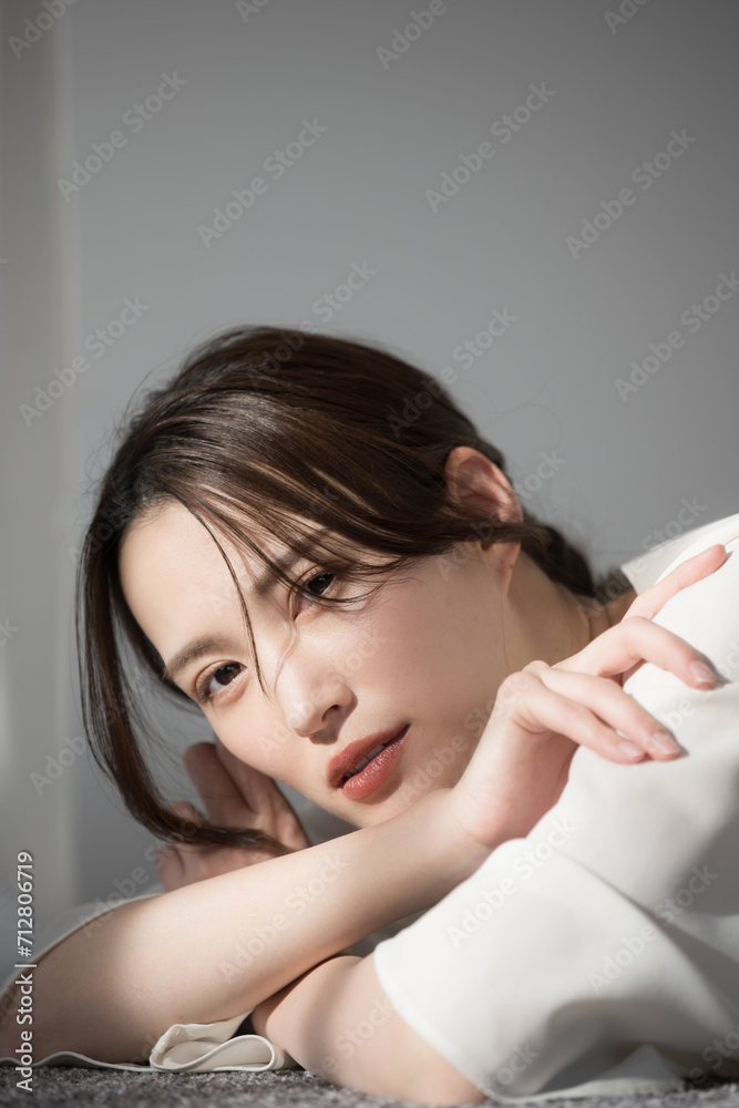日差しの中美人なけだるい表情（アンニュイ）なおしゃれなカメラ目線の女性 美容やビューティーのイメージに UVや日焼けなど