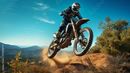Off road motorcycle performing stunt jump over canyon with blue sky background