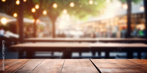 Abstract blurred background with cafe restaurant and wooden table in the foreground.