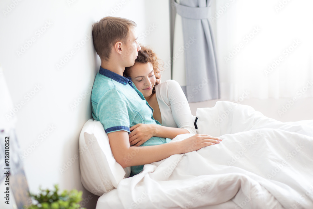 Love couple lying on white bed in morning happy and carring together Love couple lying on white bed in morning happy and carring together