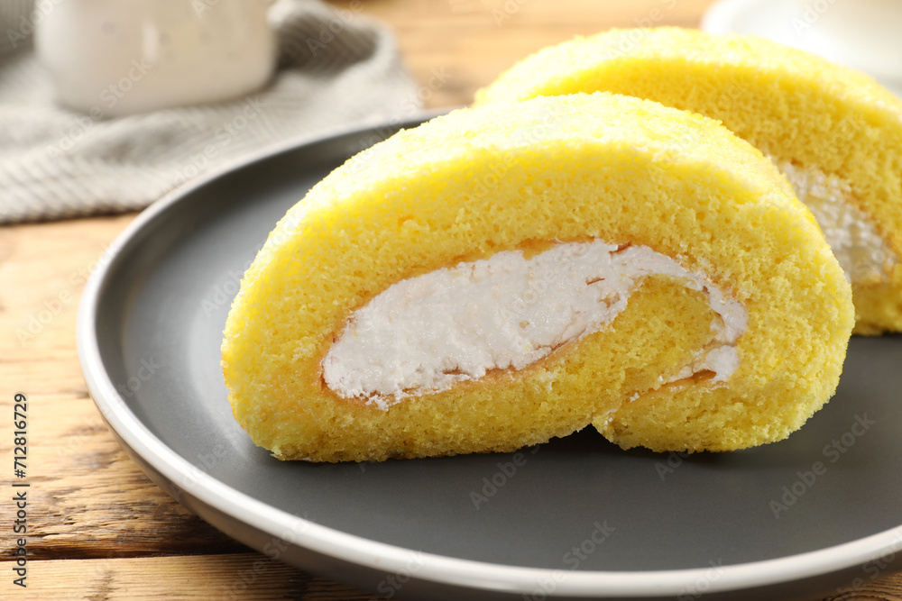 Delicious cake roll with cream filling on wooden table, closeup Delicious cake roll with cream filling on wooden table, closeup