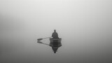 A man boating in foggy and cold weather