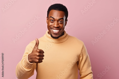  Cheerful Man Giving Thumbs Up in Casual Sweater on Pink Background
