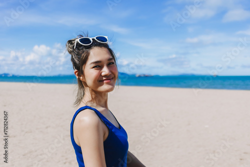 Happy smile asian woman in blue dress walking on the sunny beach of Pattaya. © Sevendeman