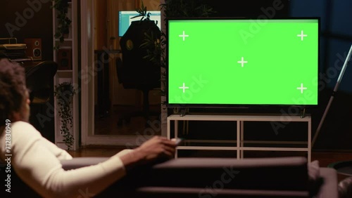 African american man using streaming services on mockup TV to binge watch series from the comfort of his apartment. Person enjoying shows on isolated screen television set during leisure time on couch