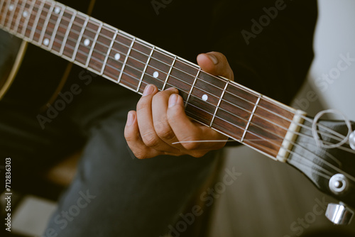 Photo detail of unknown person playing an acoustic guitar. Concept of hobbies.
