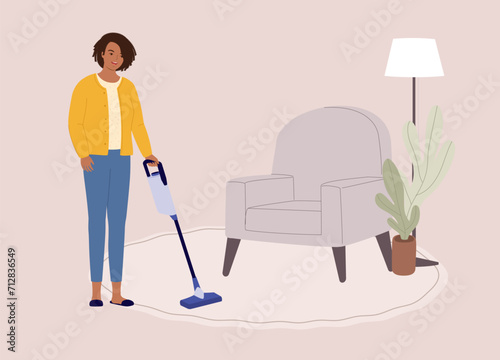 One Smiling Black Woman Using A Cordless Vacuum Cleaner Cleaning Carpet In Living Room. Full Length.