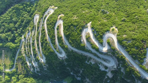 The winding road with multiple curves leads toward Papigko village in the picturesque mountainous region of Zagori, located in the Epirus region of Greece, Europe photo