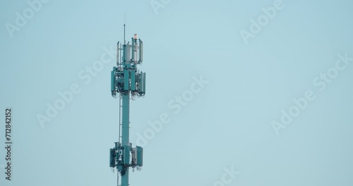 Cell phone antenna tower in blue sky photo