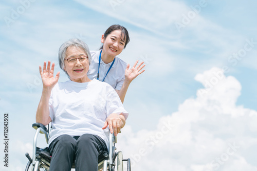 青空と介護福祉士・介護士と高齢者・シニア女性・おばあちゃん
 photo