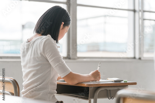 学校の教室で勉強する生徒の後ろ姿
 photo