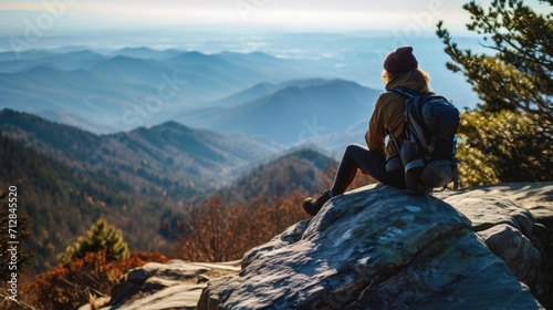 A hiker sitting on a boulder, gazing out at the breathtaking views and practicing gratitude.
