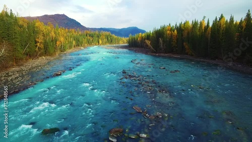 beautiful autumn landscape of Kanas Lake in the valley of Altai Mountains of Xinjiang China , stream flowing in the woods  photo