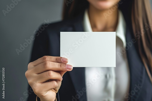 a businesswoman holding up a white blank card