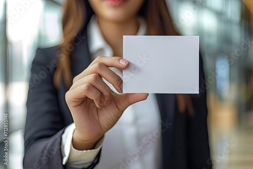 a businesswoman holding up a white blank card
