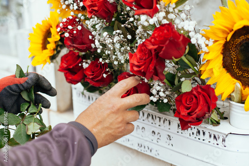 Photograph of hands placing flowers in a cemetery in South America. 