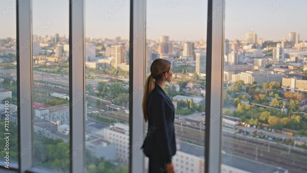 Woman leader thinking future looking panoramic window in contemporary office.
