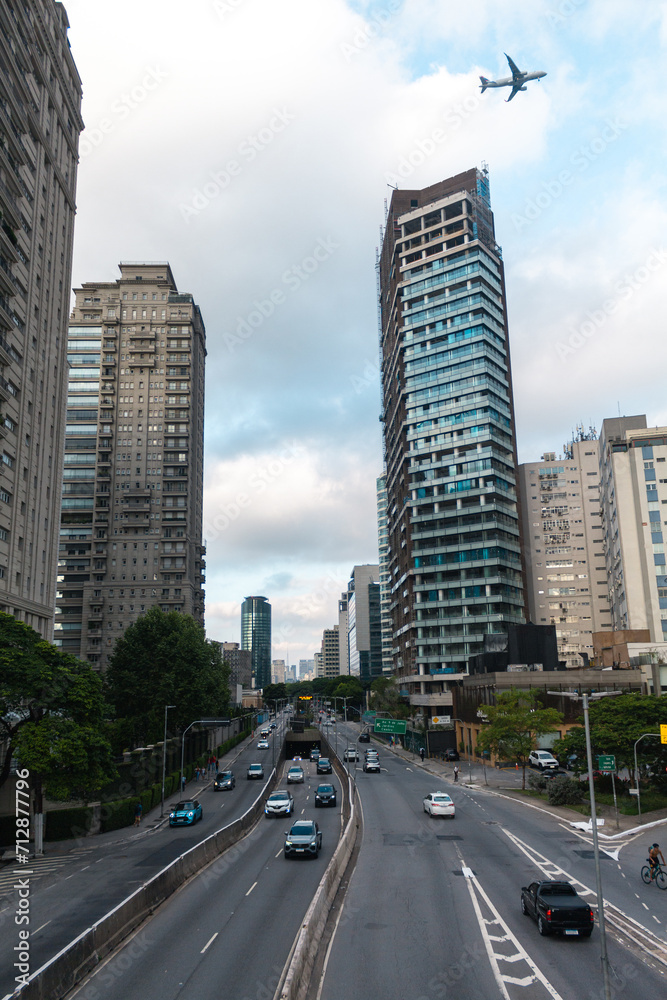 Urban landscape of the city of São Paulo with plane over the buildings, Brazil. Avenida Cidade Jardim.
