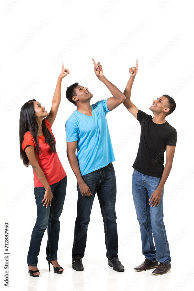 Group of happy Indian friends pointing upwards. Group of happy Indian friends pointing upwards.