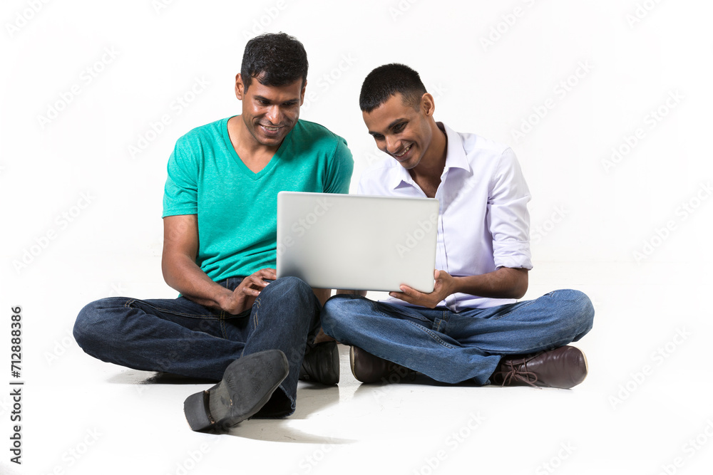Two male Indian friends using a tablet PC.