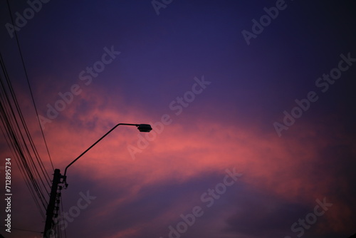unlit street Light pole during Dramatic sunset hour.