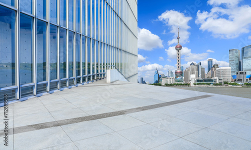 Empty square floor and glass wall with modern city buildings in Shanghai