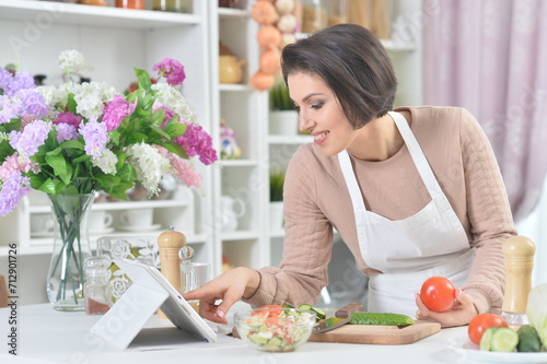 Portrait of a beautiful woman cooking at kitchen