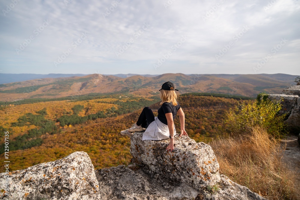 woman on mountain peak looking in beautiful mountain valley in autumn. Landscape with sporty young woman, blu sky in fall. Hiking. Nature woman on mountain peak looking in beautiful mountain valley in autumn. Landscape with sporty young woman, blu sky in fall. Hiking. Nature