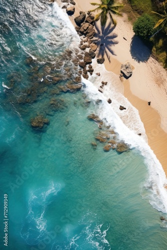 Aerial shot of a tropical beach with waves crashing on sandy shore