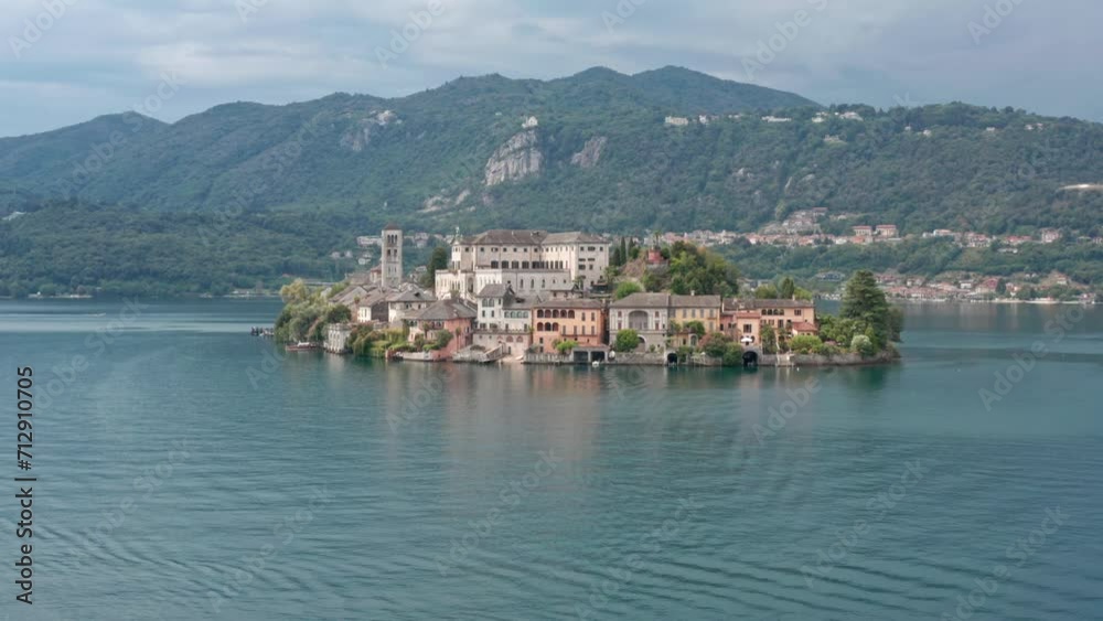 Isola di San Giulio on Lake Orta, Italy, with historical buildings surrounded by water and green hills in the background, aerial view Isola di San Giulio on Lake Orta, Italy, with historical buildings surrounded by water and green hills in the background, aerial view