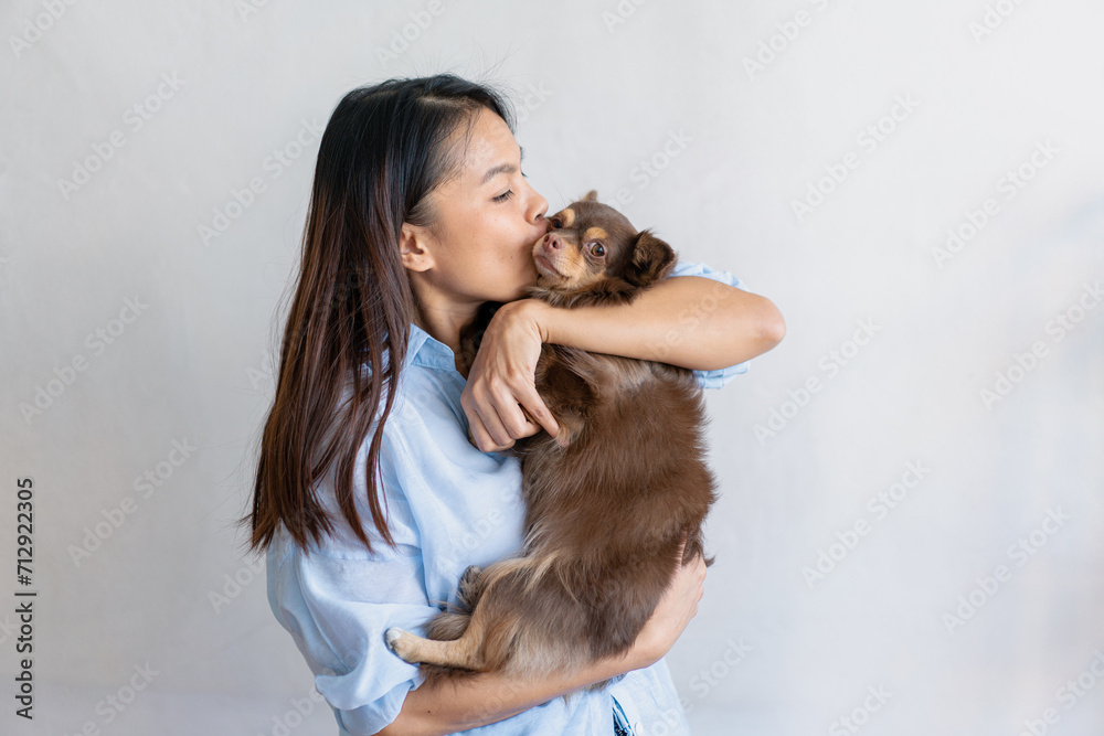Joyful fit woman sitting having fun with cute dog on the armchair at living room one autumn day , friendship and love for pets. Joyful fit woman sitting having fun with cute dog on the armchair at living room one autumn day , friendship and love for pets.