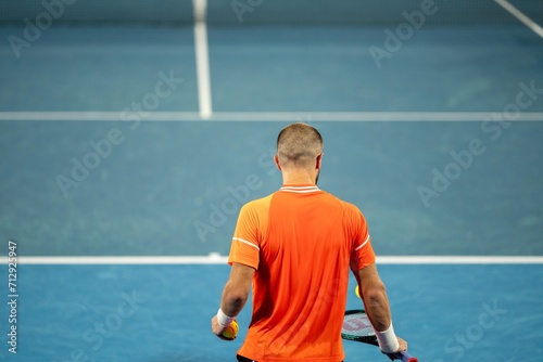 playing a tennis match on a blue tennis court © William