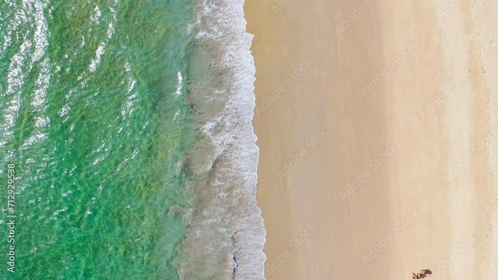 Tourism walking on a tropical beach with an aerial drone top down view of blue waves breaking. Tourism walking on a tropical beach with an aerial drone top down view of blue waves breaking.