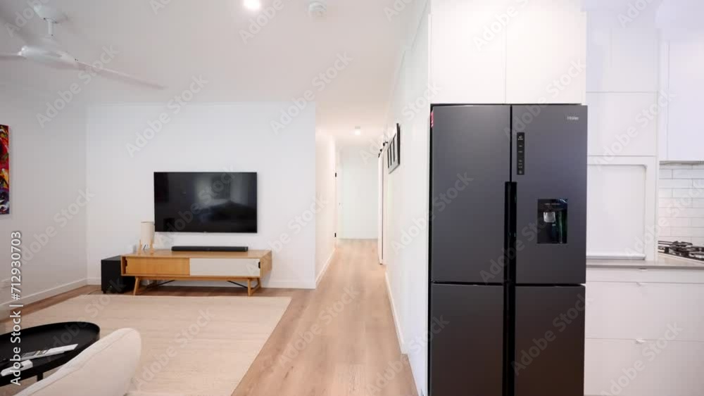 Long sweeping push thought from modern open plan living room down hallway into small contemporary bedroom. Styling interior design wooden floor boards Long sweeping push thought from modern open plan living room down hallway into small contemporary bedroom. Styling interior design wooden floor boards