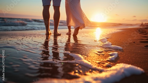 barefoot couple on the beach on the sunset by the ocean and enjoying time together