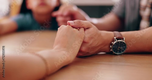 Family, holding hands and praying at table in home for faith in God, spiritual or gratitude with trust. Prayer, people or closeup of religion, understanding and thankful for blessing, grace or Christ photo