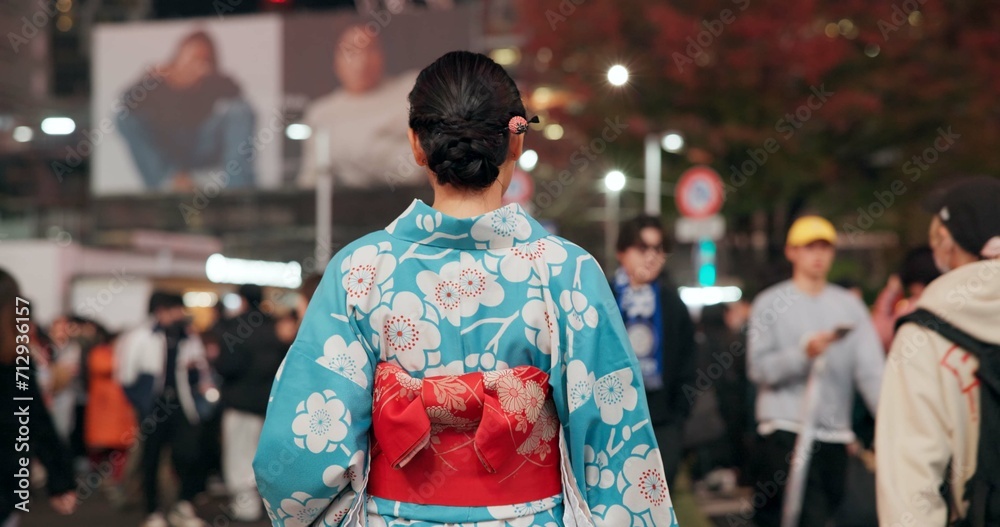 Back, city and Japanese woman on street at night with crowd for culture, heritage or tradition. Travel, fashion kimono and person walking on road of urban Tokyo town for vacation or sightseeing