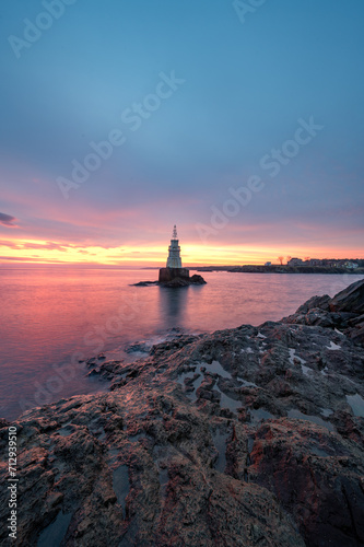 Solitude Radiance: Lone Lighthouse at Sunrise © VasilAndreev Photo