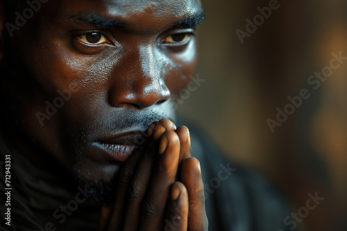 Praying adult African American man with folded hands, religion and faith