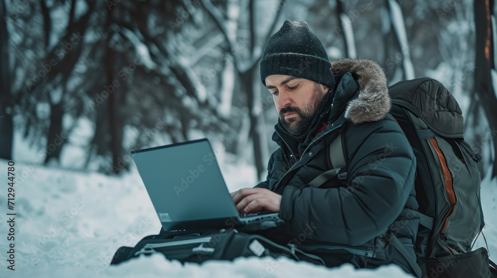 Russian guy typing on his laptop in a russian winter outdoor
