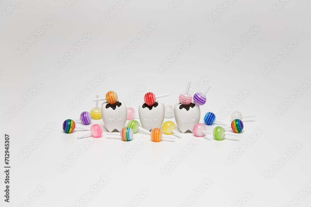 Decay tooth and colorful sweet candy figure on white background, eat sweet a lot made toothache and cavities tooth, Dental concept. Decay tooth and colorful sweet candy figure on white background, eat sweet a lot made toothache and cavities tooth, Dental concept.
