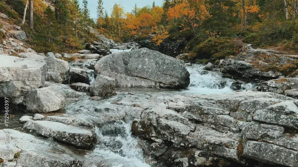 A beautiful waterfall in the autumn mountains beyond the Arctic Circle in the north, in Khibiny, Murmansk region. Panoramic view of a beautiful waterfall in the mountains in autumn, Kola Peninsula 4К